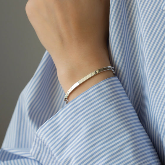 wrist of person in white and blue striped shirt with chunky bracelet in sterling silver