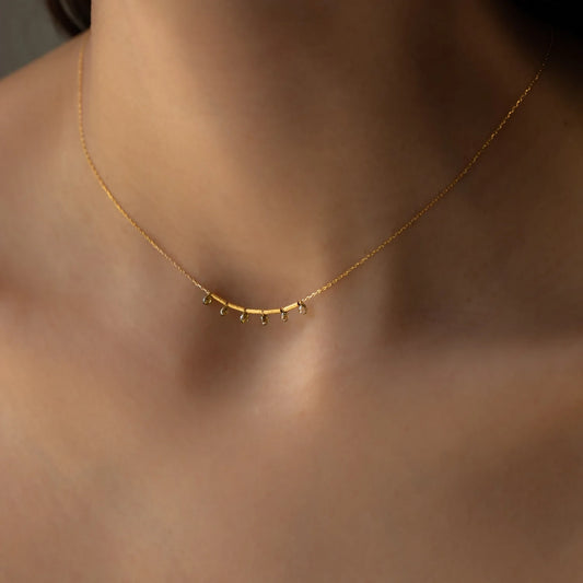 close up of Necklace AURORA in yellow gold with six green diamond pendants worn on around womans neck