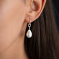 close up of ear with diamond earring hoop and pearl pendant in 18 KT rose gold