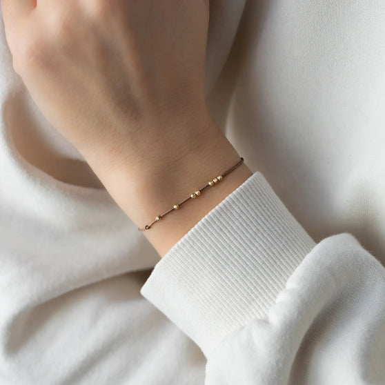 Wristband LANA in yellow gold worn on womans arm
