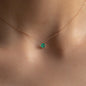 close up of woman wearing necklace mavis with emerald pendant