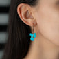 woman wearing hoop earring with pendant SOL in rose gold with precious stone turquoise