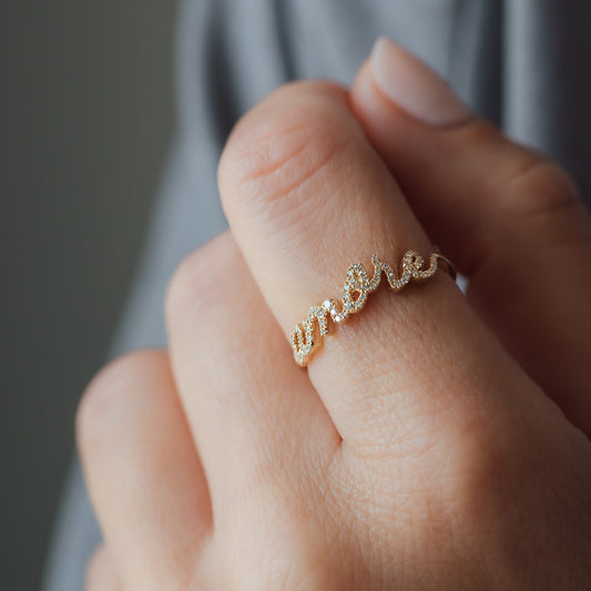 Hand with rings in yellow gold and white diamonds and font