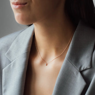 cleavage of woman in grey blazer with necklace SOUL with white diamond in rose gold