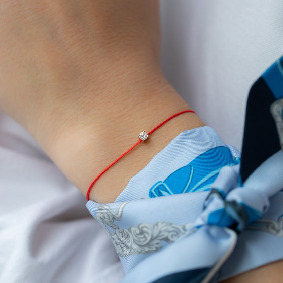 wristband SOUL in rose gold with white diamond and red ribbon worn from woman