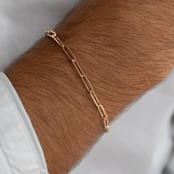 Men's wrist with shiny rose gold chain bracelet