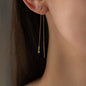 close up of earring aurora in 18 KT yellow gold with green diamond worn on woman