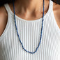 Long necklace Elliot with lapis lazuli gemstone pearls and 18 KT rose gold closure worn on woman in white shirt