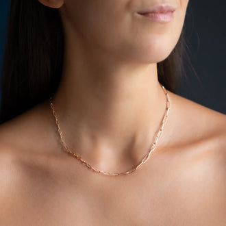Woman wearing 18 KT rose gold chain link necklace with different sized chain links
