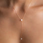 close up of long necklace sadie in y-form with two 6mm akoya pearls in 18 kt rose gold worn on around womans neck