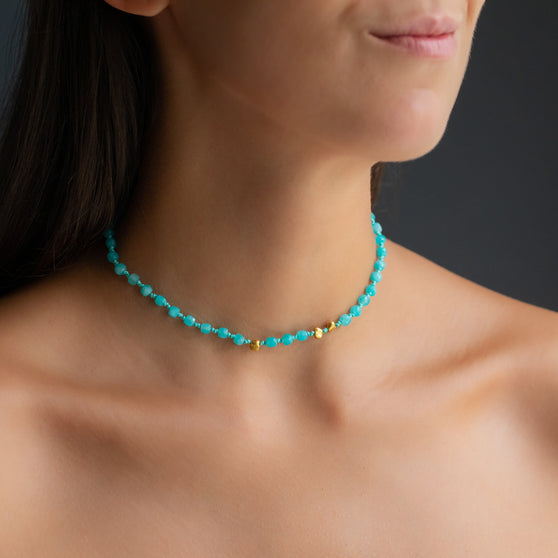 Womans cleavage with turquoise necklace with amazonite gemstones and yellow gold nuggets