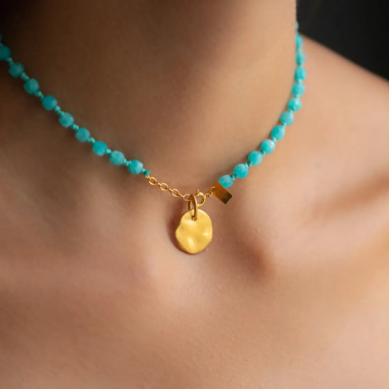 close up of necklace closure in yellow gold with round yellow gold pendant and amazonite gem stones