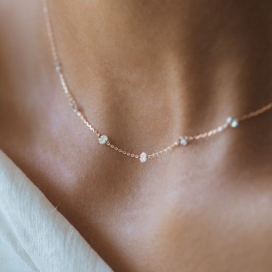 woman wearing necklace ZOE 7 in rose gold with seven white diamonds close up shot