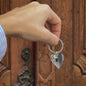 video of hand holding steel keychain in heart shape