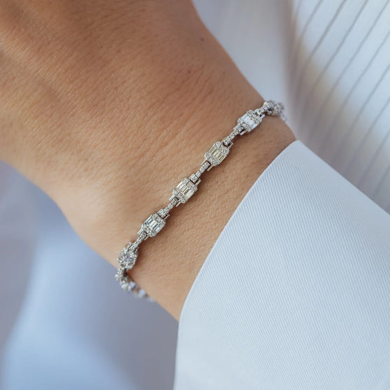 details of woman wearing diamond bracelet and white shirt