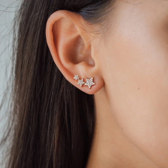 Woman wearing Earring with stars and diamonds in rose gold