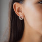 Woman with dark hair wearing diamond earring 