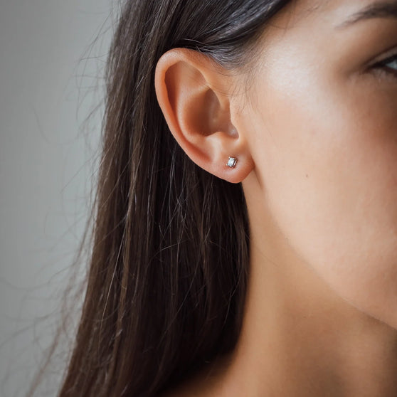 womans face and ear with diamond earring 