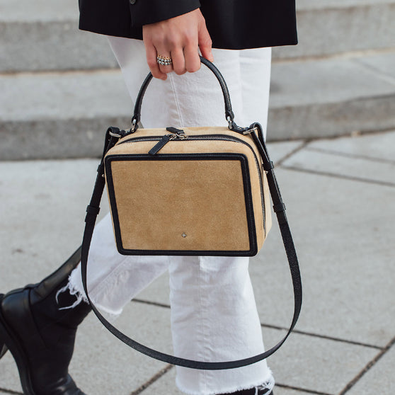 Close up of woman wearing black and white outfit and handbag ELLEN in beige