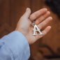 Hand holding keychain with big letter A and little star in front of brown wood door