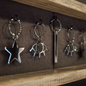collection of keychains in star shape, eye shape and long bar shape on wall 