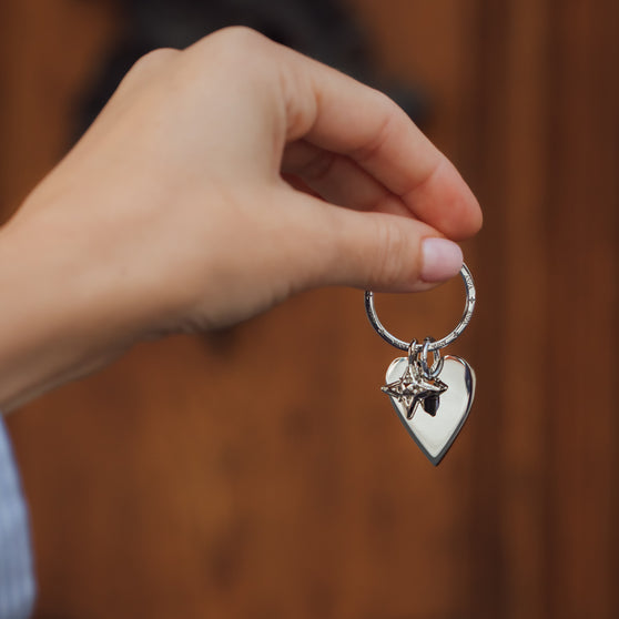 womans hand holding heart keychain with ANNA signature star