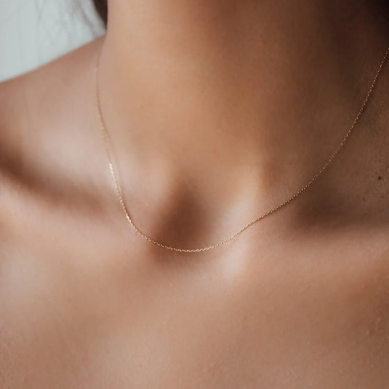 woman wearing fine yellow gold necklace without pendant