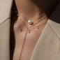 close up of woman in beige blazer wearing necklaces in layering with necklace Hana with white pearl, necklace ANNA Signature Star 7 and necklace Lenox Eve in Roségold