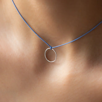 close up of necklace LEXI with round pendant in sterling silver and blue thread