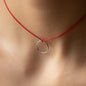 close up of necklace LEXI with round pendant in sterling silver and red thread worn