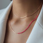Necklace Nala in rose gold with pink details worn from woman in white blazer