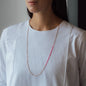 Necklace Nala in rose gold with pink details worn from woman in white shirt