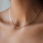 detail of woman wearing yellow gold chain necklace