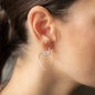 Woman wearing hoop earring with heart shaped pendant Emotion in sterling silver 
