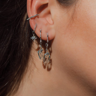 womans ear with ear cuff earrings and pendant with aquamarin stone 