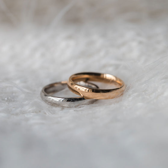 rose gold and white gold wedding ring on white fury background