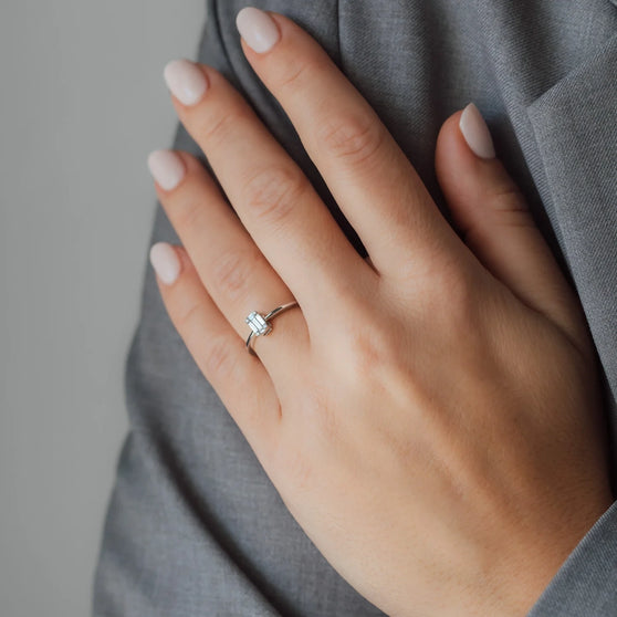 Frauenhand mit Ring in Weißgold mit weißem Diamanten 