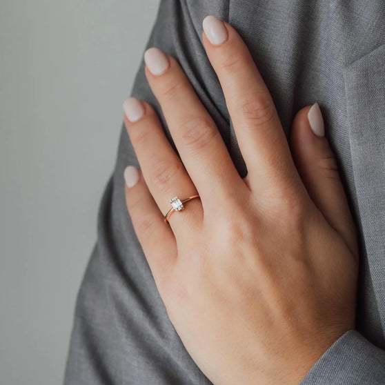 Frauen Hand mit Ring in Roségold und weißem Diamanten 