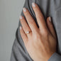 Frauen Hand mit Ring in Roségold und weißem Diamanten 