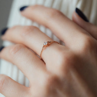 close up of ring SOUL in rose gold with white diamond on womans finger