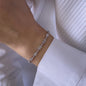 womans hand wearing white diamond bracelet and white shirt