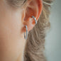 detail of womans ear with earring jolie in size 20mm with white diamonds in white gold