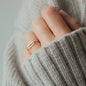 hand with chain ring in rosegold and grey knitwear