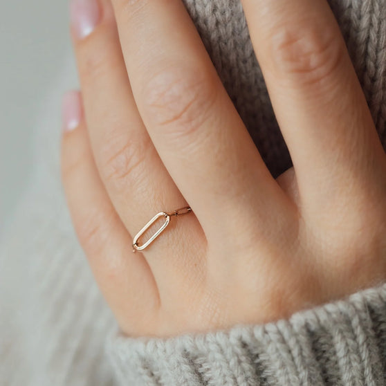 detail of hand with rosegold chain ring on woman